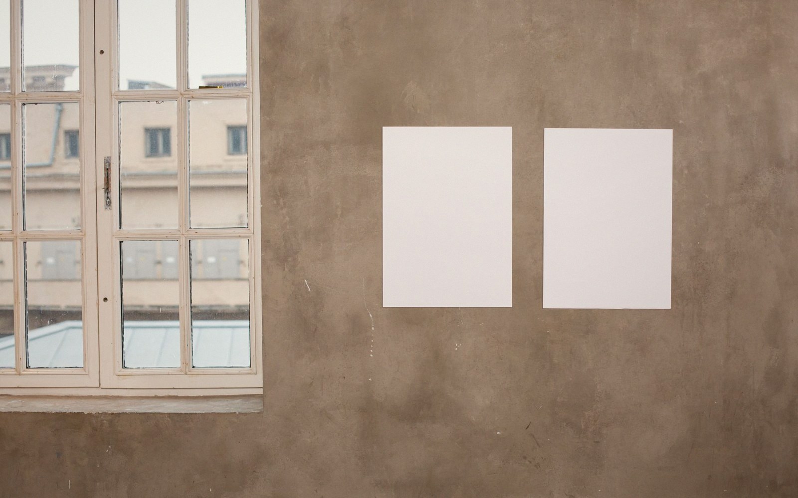An empty white room with hanging marks and pencil lines